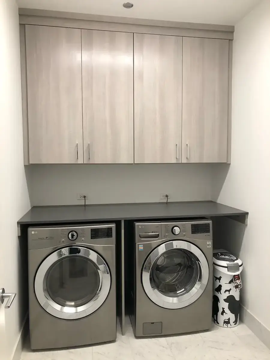 Custom laundry room with full-span upper cabinets over washer and dryer