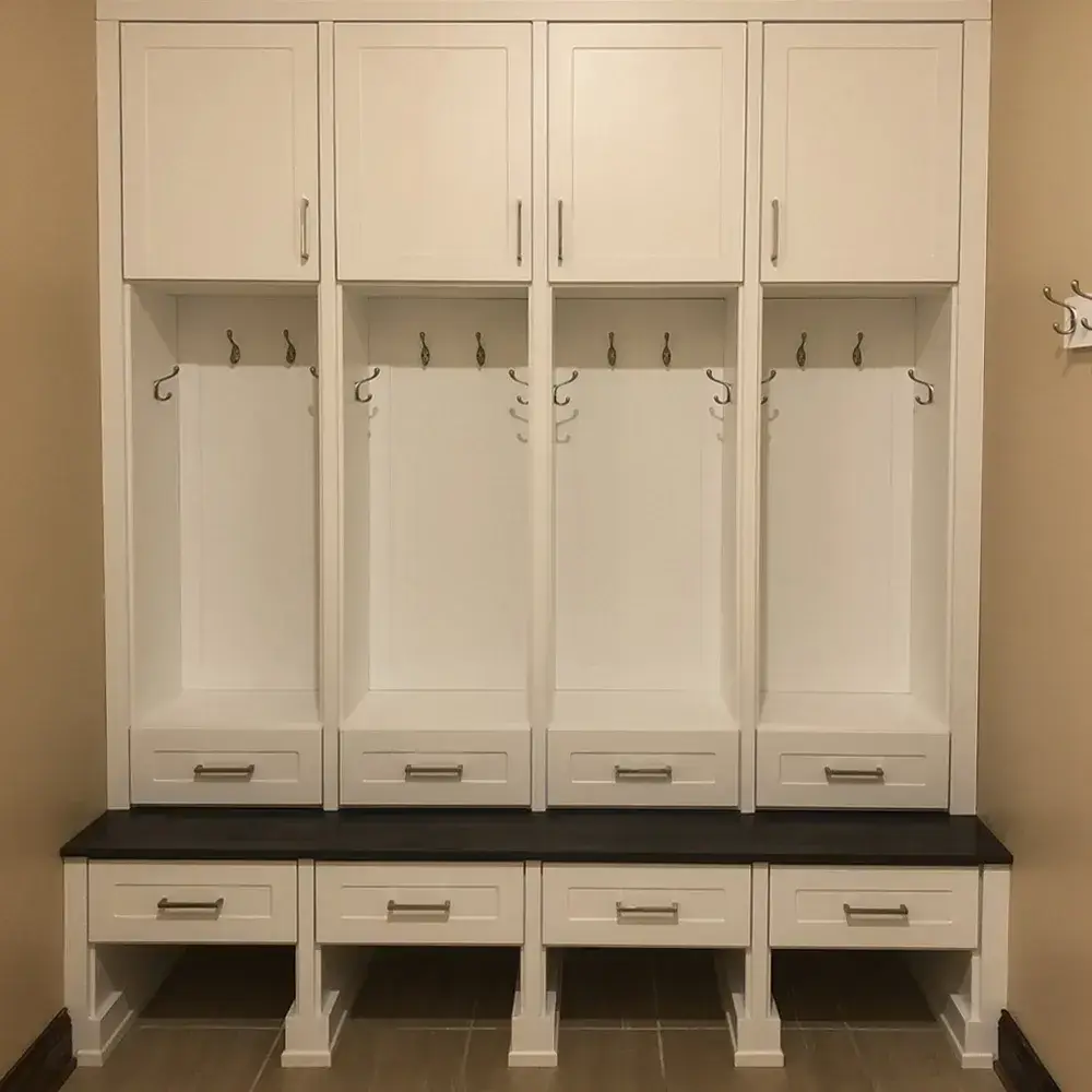 Custom mudroom with four-bay locker system, bench, and upper cabinets